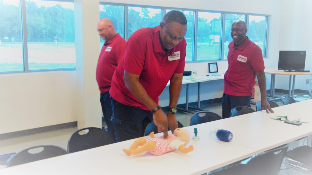 Several people engaged in practice sessions with a manikin, highlighting collaborative training and skill development.