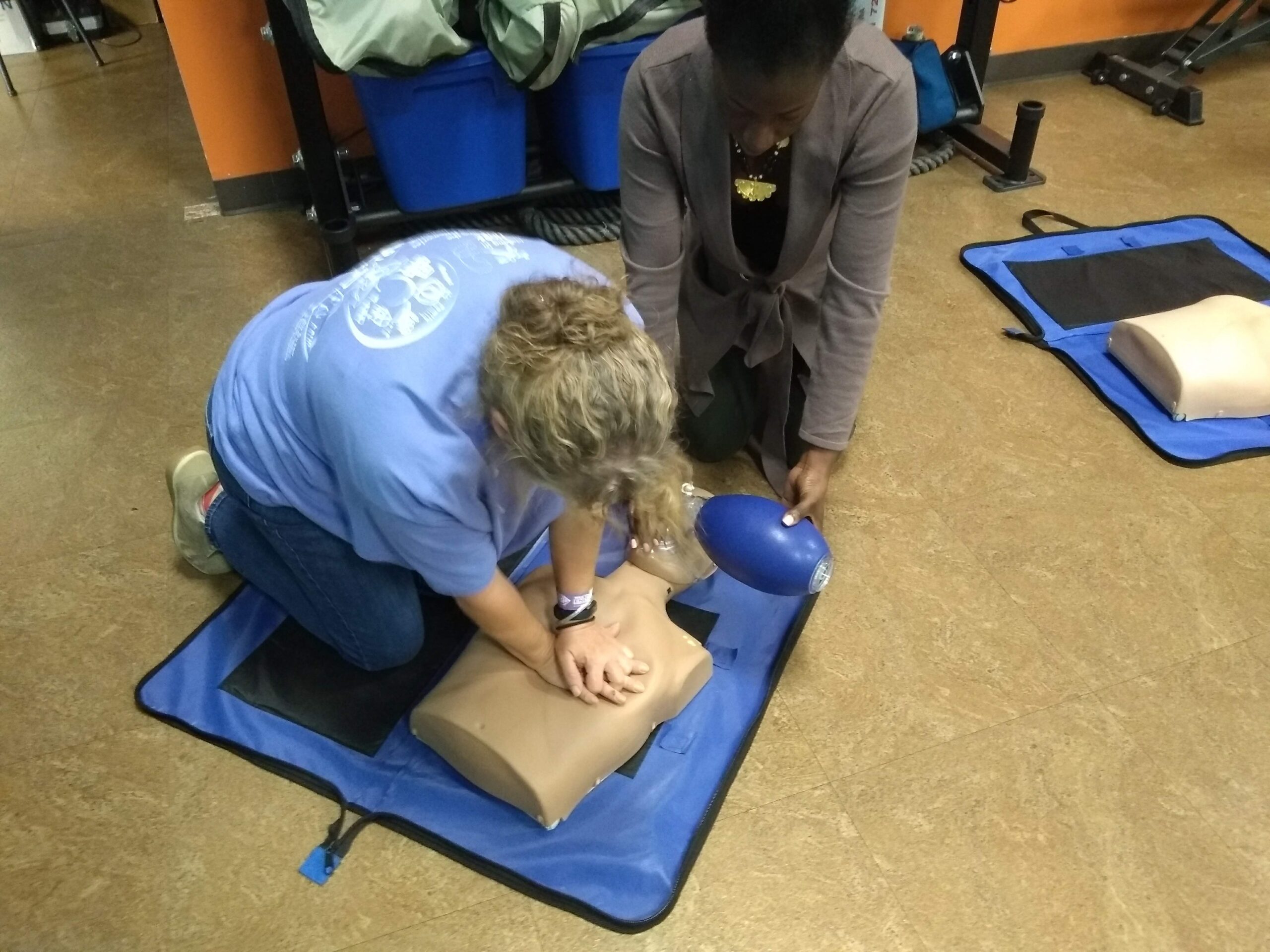 A woman demonstrates CPR techniques to another, highlighting the importance of CPR and BLS certification in saving lives_BLS near me